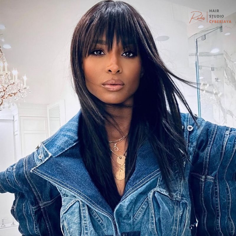 Dark Hair Colors You'll Want to Dye Your Hair ASAP A woman with long, flowing dark hair featuring striking blue balayage highlights that create a dramatic and artistic effect.