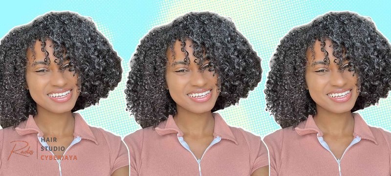 How to Detangle Curly Hair in 5 Steps A person detangling their curly hair with a wide-tooth comb