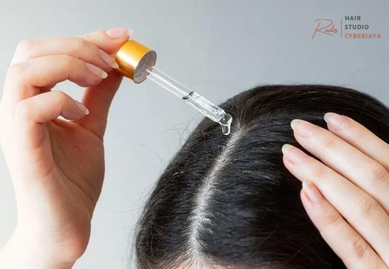 A person gently massages hair oil into their scalp, demonstrating a common method for when to use oil in hair for scalp health.