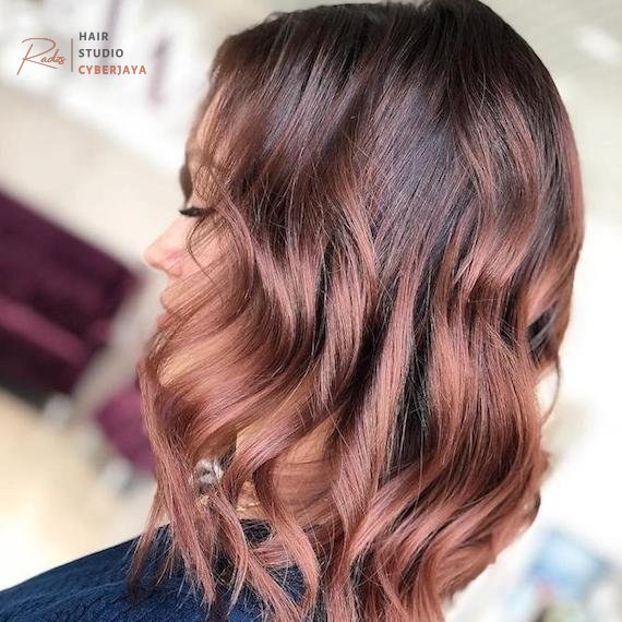 Rose Gold Hair: The Trend That Keeps Coming Back Woman with shoulder-length wavy rose brown hair