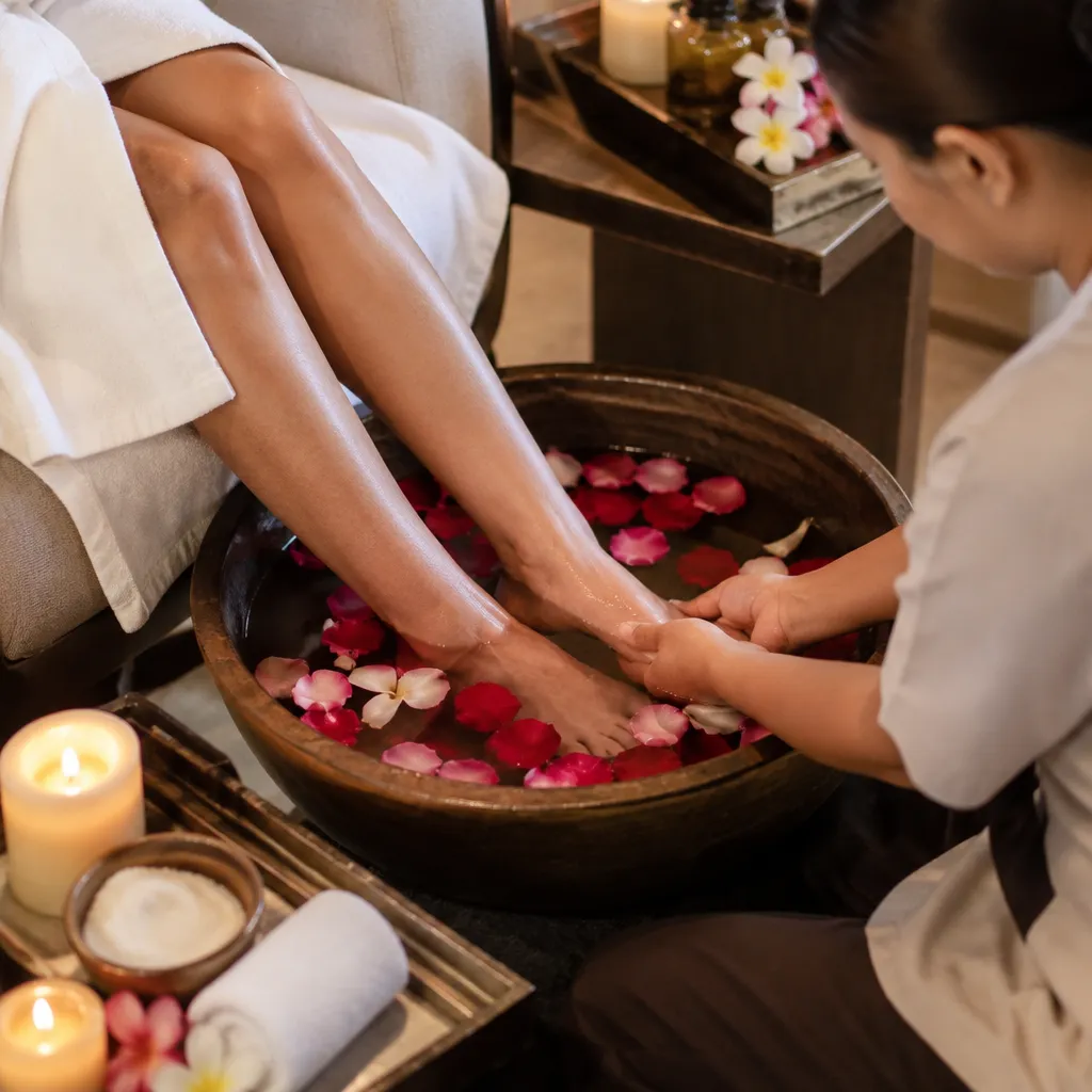 Luxurious pedicure experience with rose petals and candles in warm water.